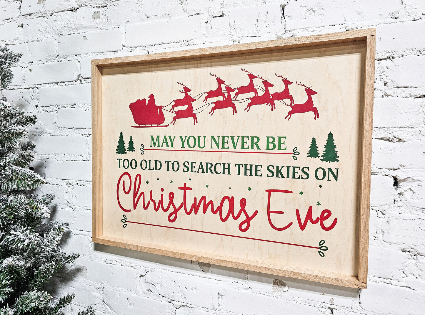 may you never be too old to search the skies on christmas eve holiday wooden sign wall decor hanging with santa claus in sleigh and reindeer at top of sign