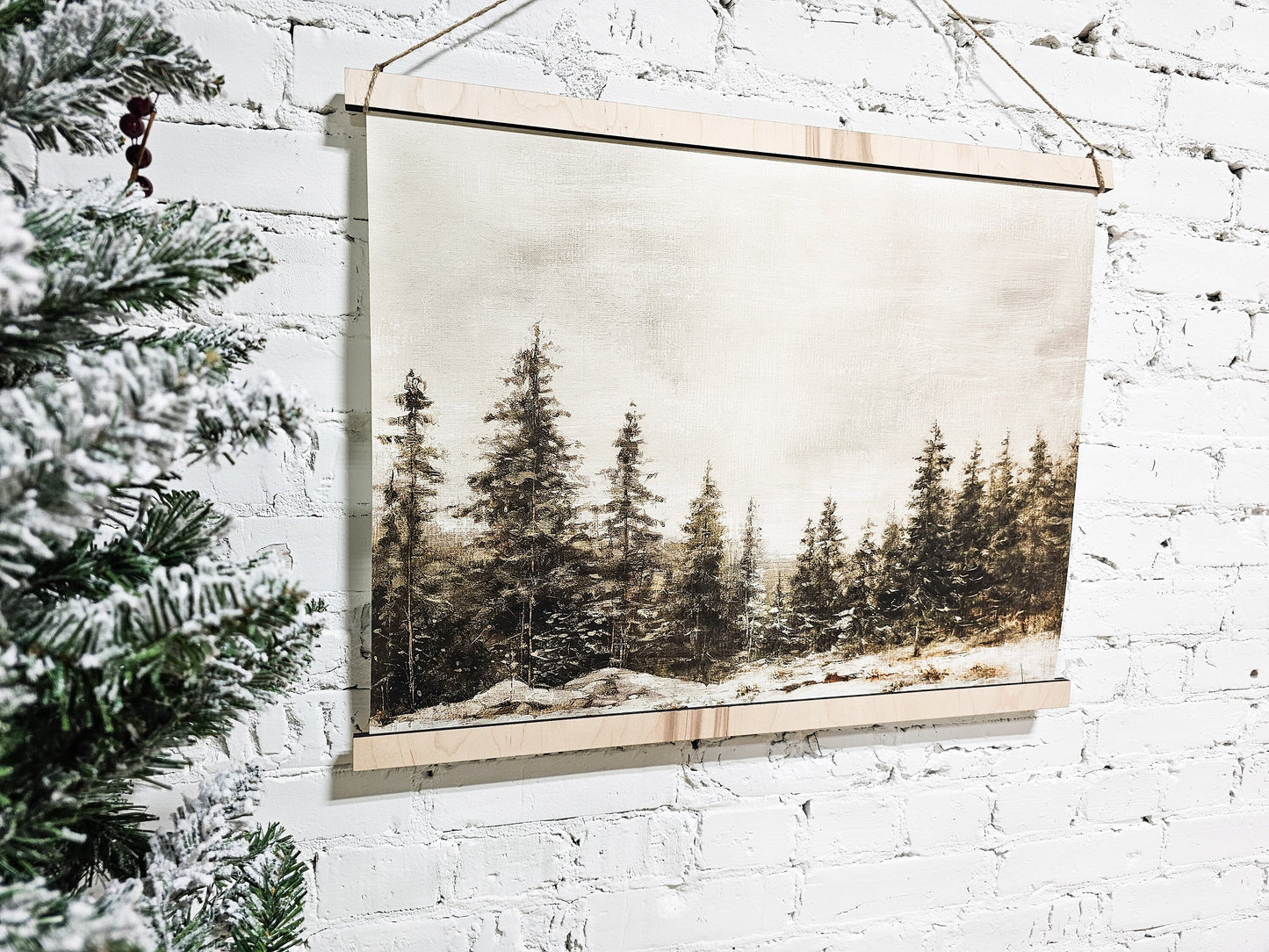 winter landscape scene painting like hanging framed canvas for wall decor, pictured on the sign is wintery pine trees in a snowy environment with a vintage moody look