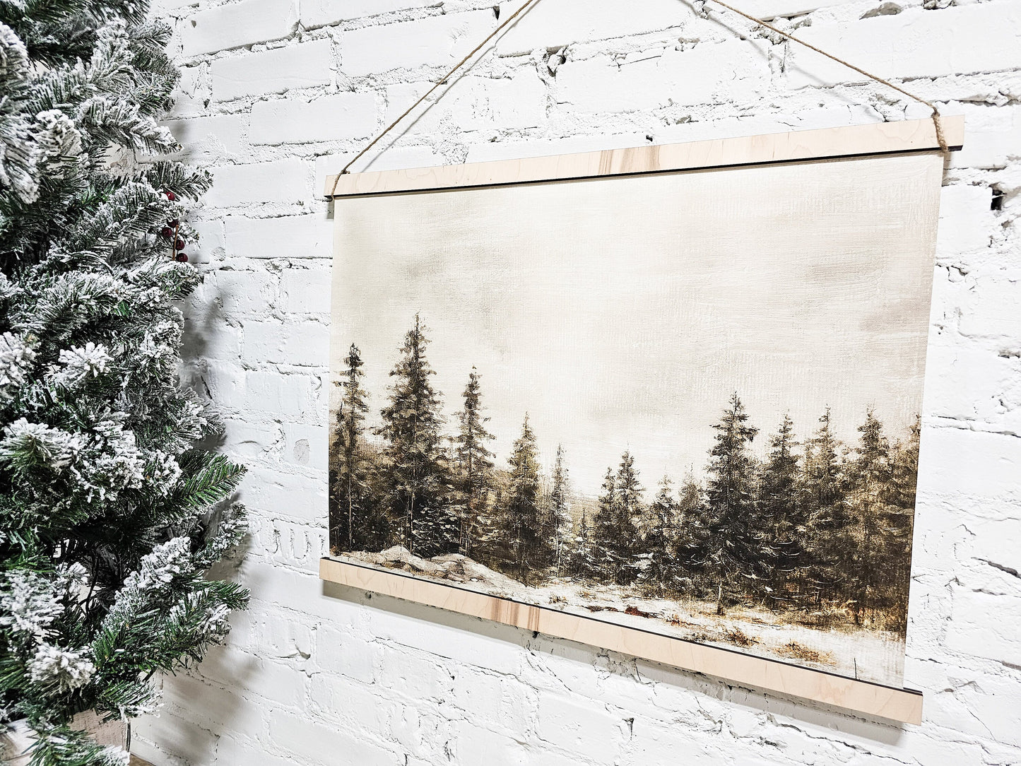 winter landscape scene painting like hanging framed canvas for wall decor, pictured on the sign is wintery pine trees in a snowy environment with a vintage moody look