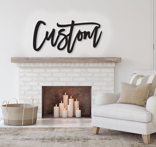May include: A white brick fireplace with a black metal mantel above it. The word 'Custom' is written in black script on the mantel. The fireplace has a black hearth and a white brick surround. There are six white candles in the fireplace. A white armchair with a tan throw pillow is in the foreground.