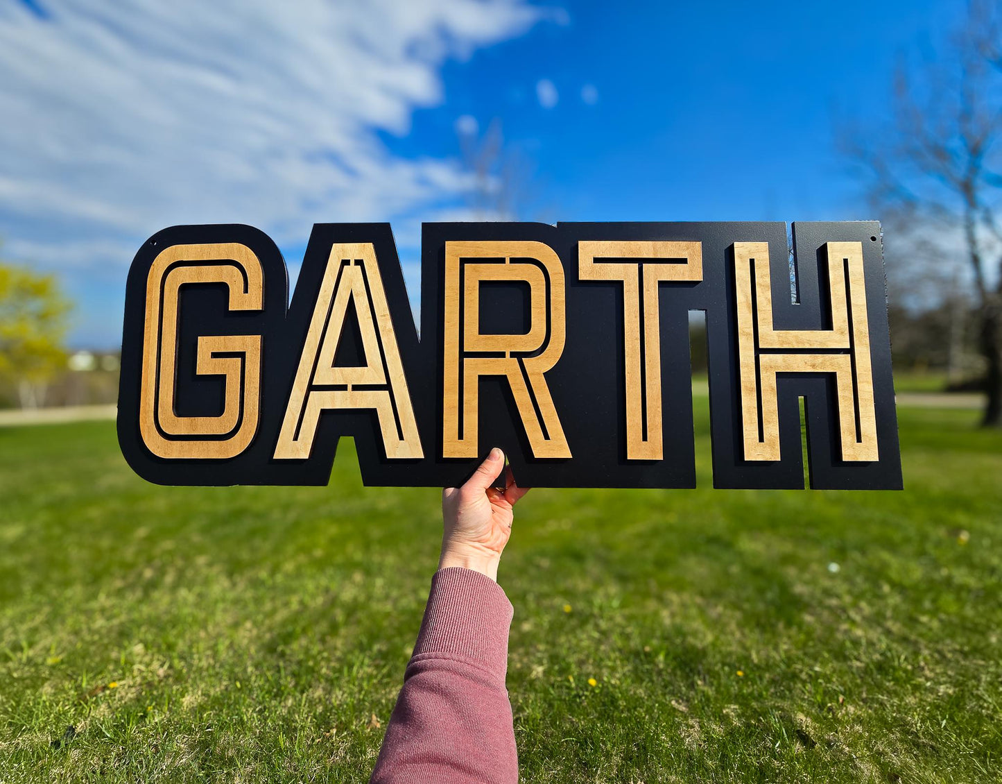 modern black/natural name sign with black backer, light colored wood name GARTH print font, all capitals