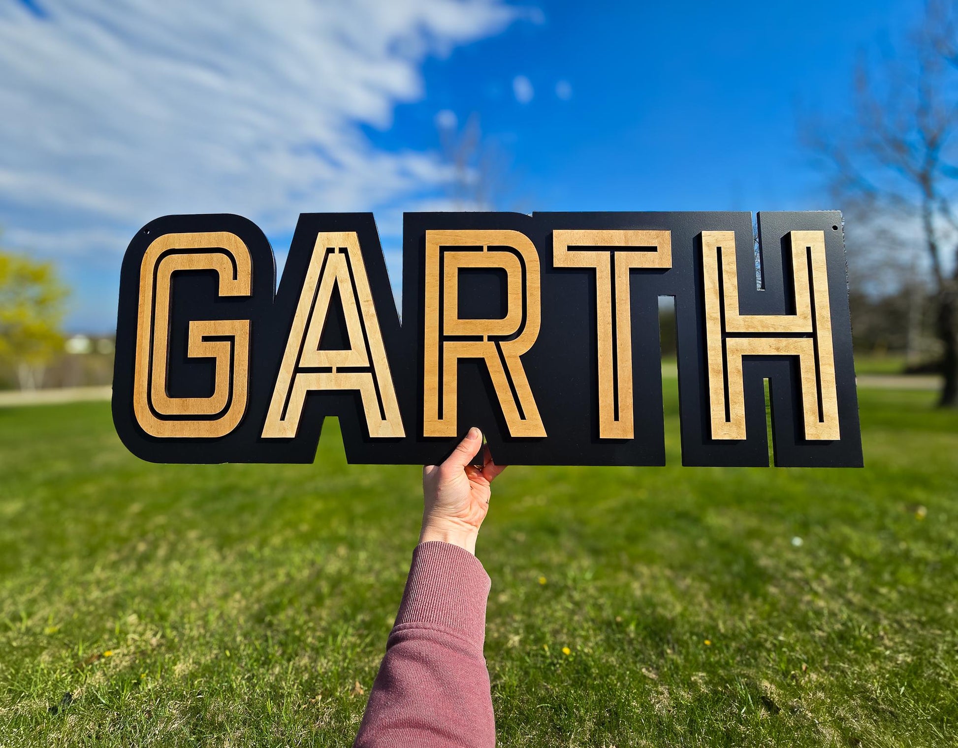 modern black/natural name sign with black backer, light colored wood name GARTH print font, all capitals